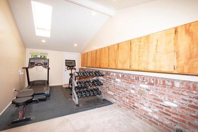 exercise room with brick wall, lofted ceiling with skylight, and carpet floors