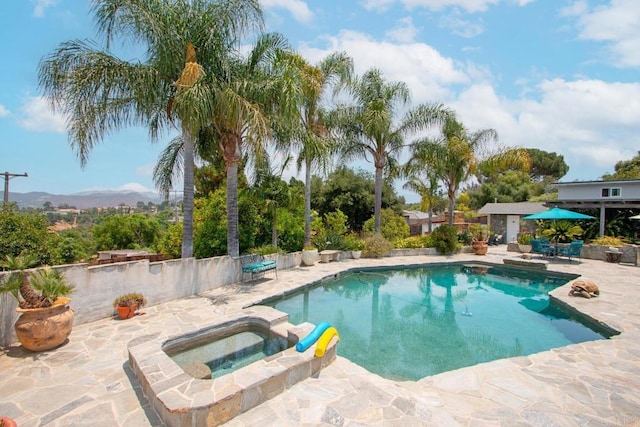 view of swimming pool with a mountain view, a patio, and an in ground hot tub