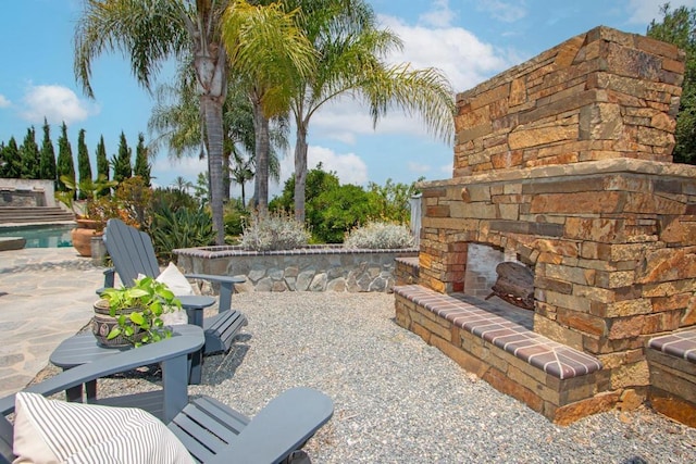 view of patio / terrace featuring an outdoor stone fireplace