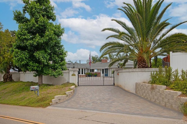 view of front facade with decorative driveway, a gate, and a fenced front yard