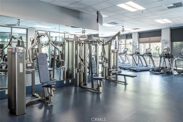 exercise room with a paneled ceiling and ceiling fan