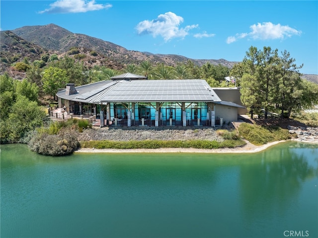 rear view of property with a water and mountain view