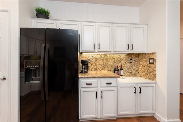 kitchen featuring white cabinetry, black fridge with ice dispenser, and decorative backsplash