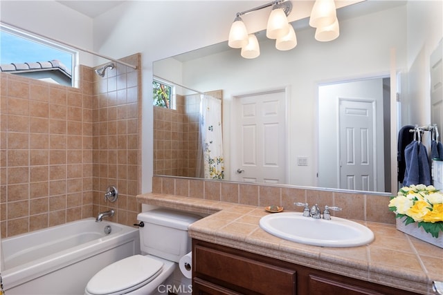 full bathroom with tiled shower / bath, vanity, and toilet