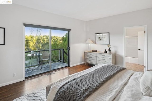 bedroom featuring ensuite bathroom, hardwood / wood-style floors, and access to exterior