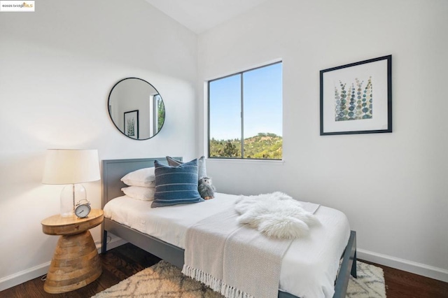 bedroom with dark hardwood / wood-style floors