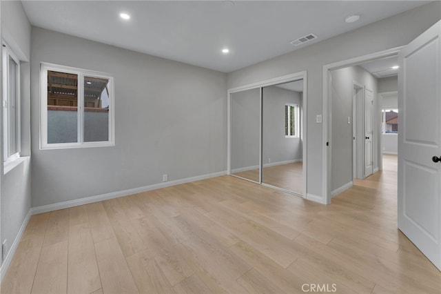 unfurnished bedroom with light hardwood / wood-style floors and a closet