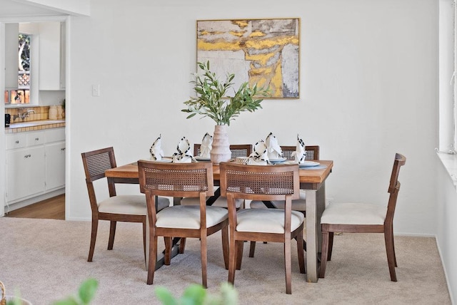 carpeted dining area with sink