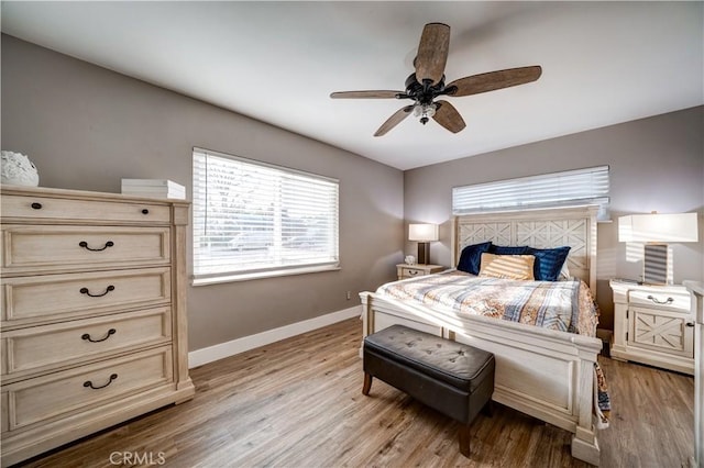 bedroom with multiple windows, ceiling fan, and light wood-type flooring