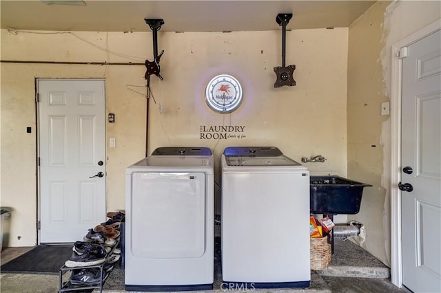 clothes washing area featuring separate washer and dryer and sink