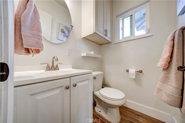 bathroom with hardwood / wood-style flooring, vanity, and toilet