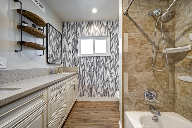 full bathroom with vanity, tiled shower / bath, hardwood / wood-style flooring, and toilet