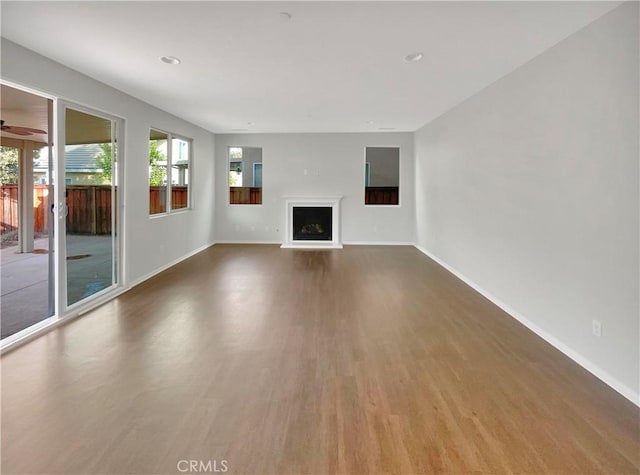 unfurnished living room featuring wood-type flooring and ceiling fan