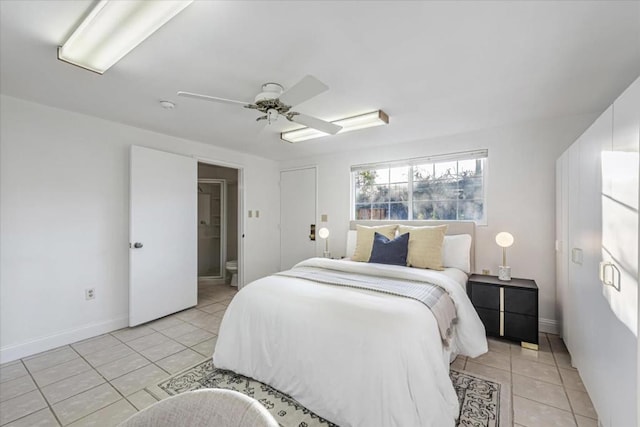 tiled bedroom featuring ensuite bath and ceiling fan