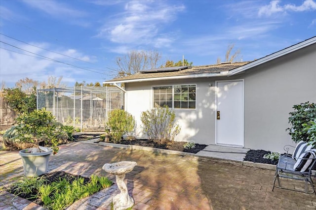 property entrance featuring a patio and solar panels