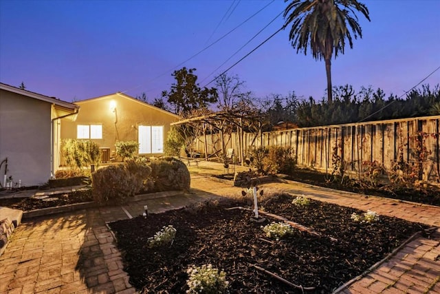 yard at dusk featuring a patio