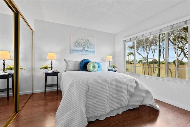 bedroom with dark hardwood / wood-style floors, a closet, and a textured ceiling