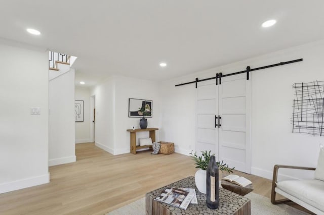 living room featuring a barn door and light hardwood / wood-style floors