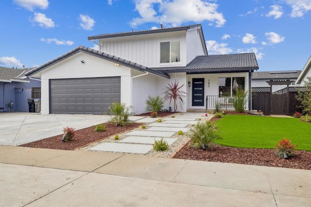 view of front of property featuring a garage, covered porch, and a front lawn