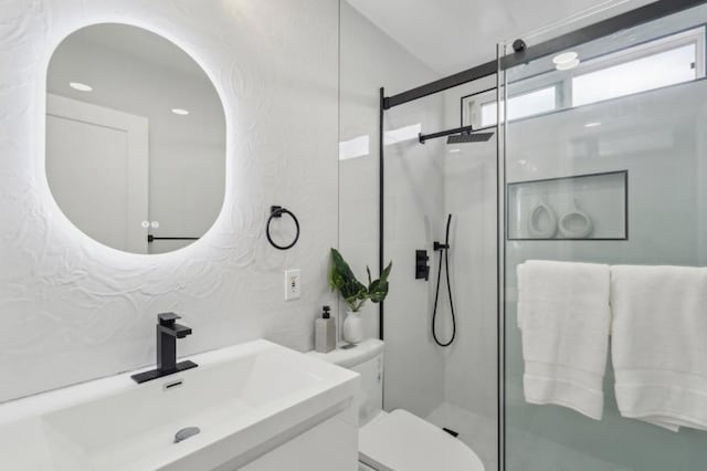 bathroom featuring vanity, toilet, and a shower with door