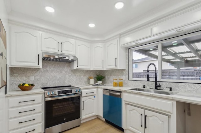 kitchen with sink, decorative backsplash, stainless steel appliances, and white cabinets