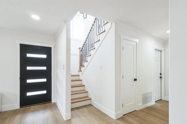 foyer featuring light hardwood / wood-style flooring and ornamental molding