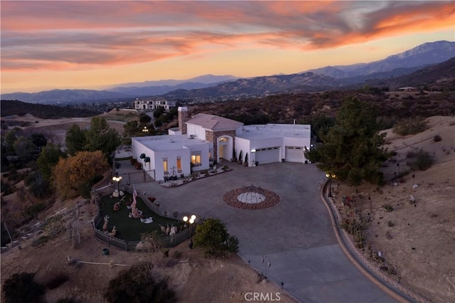 aerial view at dusk featuring a mountain view