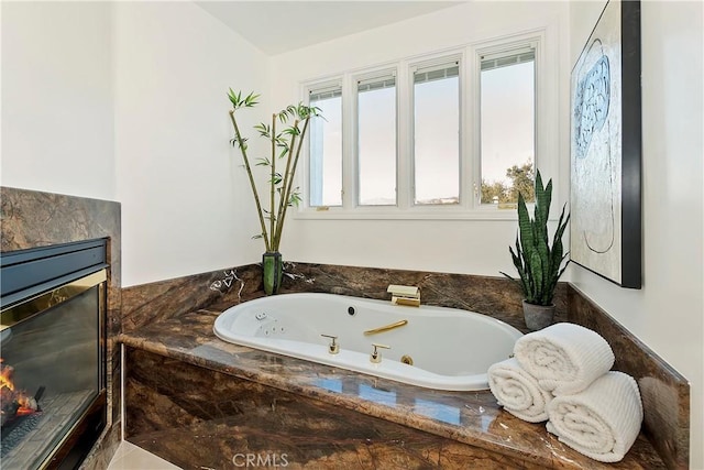 bathroom with a relaxing tiled tub and a premium fireplace