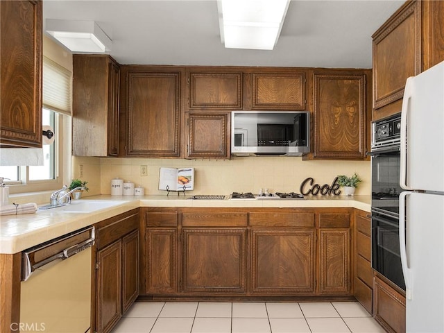 kitchen with sink, white appliances, decorative backsplash, and light tile patterned floors