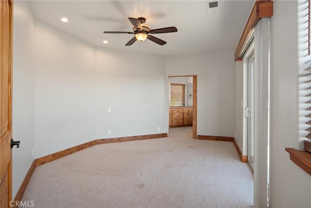 unfurnished bedroom featuring connected bathroom, light colored carpet, and ceiling fan