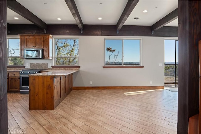 kitchen featuring stainless steel appliances, beamed ceiling, light wood-type flooring, and kitchen peninsula