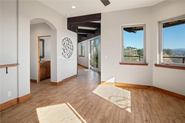 interior space with beam ceiling and light hardwood / wood-style floors