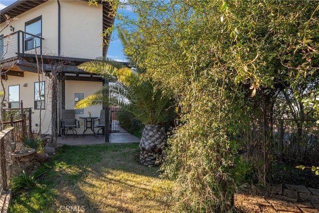 back of property with a yard and a patio area