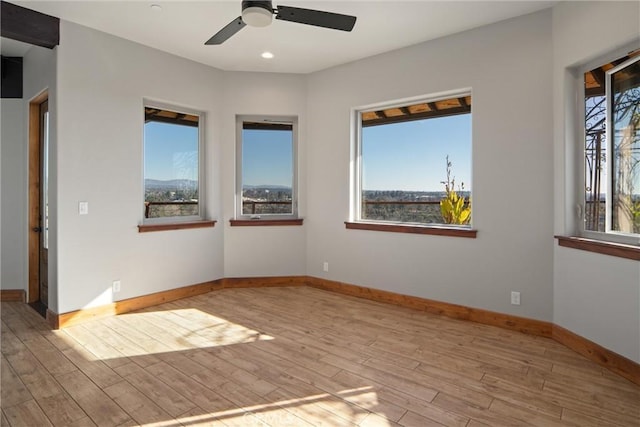 unfurnished room with ceiling fan, a healthy amount of sunlight, and light hardwood / wood-style floors