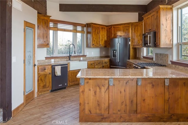 kitchen featuring sink, high quality fridge, kitchen peninsula, and black dishwasher