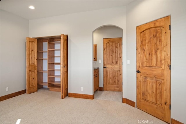 unfurnished bedroom with light colored carpet and ensuite bathroom