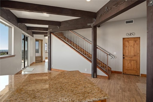 foyer featuring beam ceiling and light hardwood / wood-style flooring