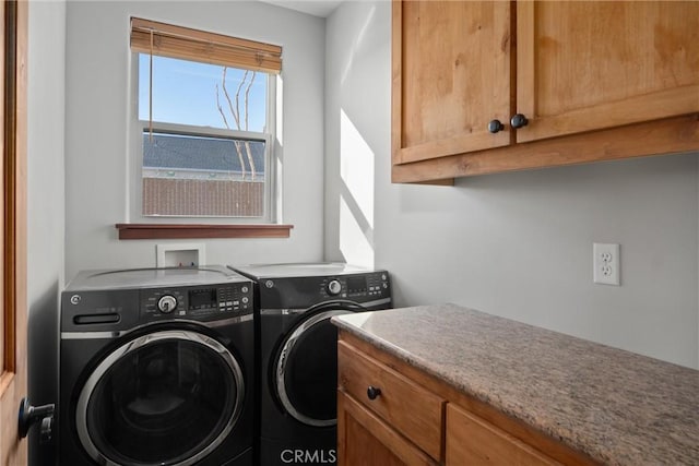 washroom with cabinets and washer and dryer