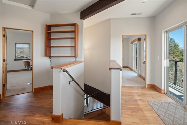 staircase featuring beamed ceiling and wood-type flooring