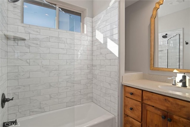 bathroom featuring tiled shower / bath and vanity