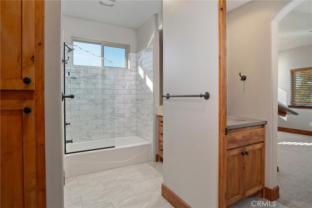 bathroom with vanity, tiled shower / bath, and a healthy amount of sunlight