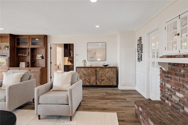 living room with hardwood / wood-style floors and crown molding