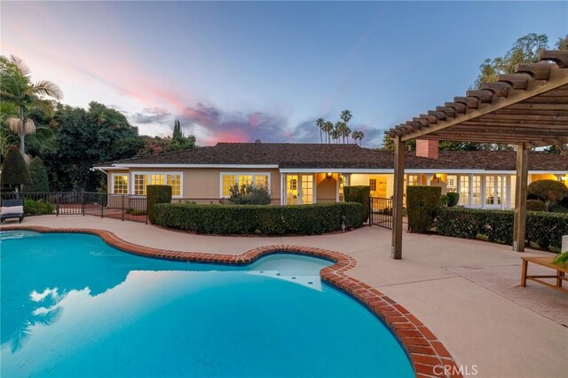 pool at dusk featuring a patio area