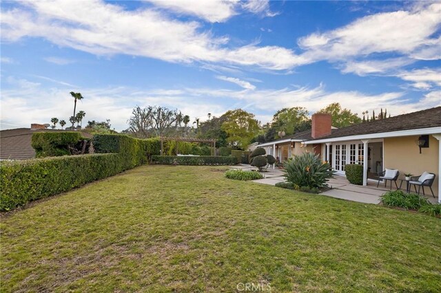 view of yard featuring a patio area and french doors