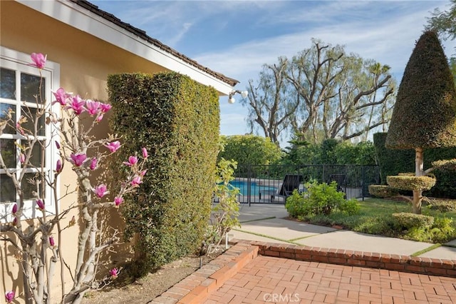 view of property exterior with a fenced in pool and a patio area