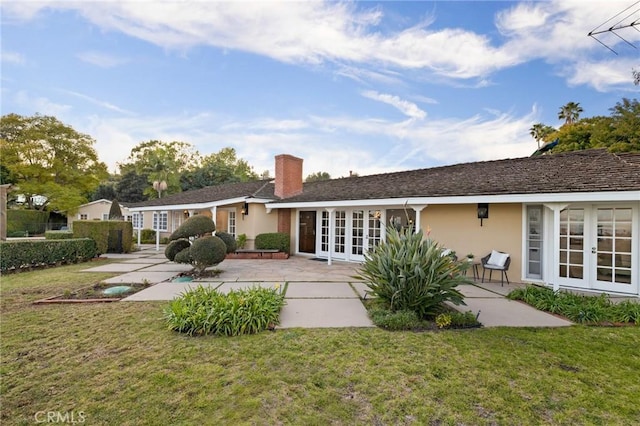 rear view of property featuring french doors, a yard, and a patio