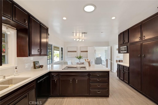 kitchen featuring black appliances, sink, dark brown cabinetry, and kitchen peninsula