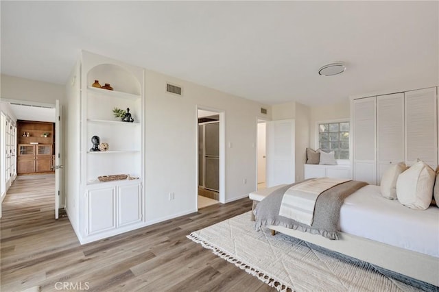 bedroom featuring ensuite bathroom, a closet, and light wood-type flooring