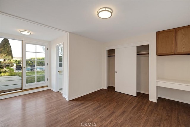 unfurnished bedroom featuring dark hardwood / wood-style floors and a closet