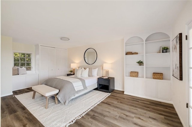 bedroom with dark hardwood / wood-style flooring and a closet